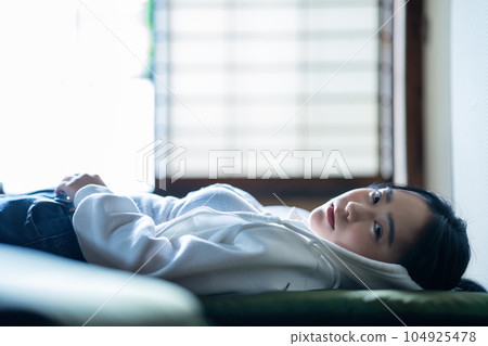 Young woman lying down and relaxing Young woman lying down and relaxing 104925478