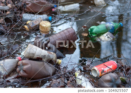 Moscow, 24.02.2020 Old plastic bottles, cans and trash lying in a ditch with water in the forest 104925507