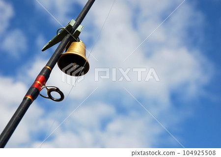 Bell fixed with clothespin on fishing rod 104925508