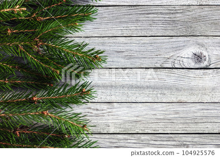 border of christmas tree branches on wooden background 104925576
