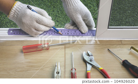 Construction worker repairing the sliding window. Construction worker repairing the sliding window. 104926020