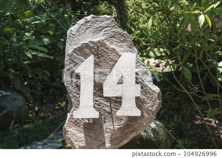 House number address 14 installed on a large rock at the yard of a residence at Costa Rica House number address 14 installed on a large rock at the yard of a residence at Costa Rica 104926996