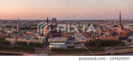 RIga rooftop view panorama at sunset with urban architectures and Daugava River. Aerial view of the Riga old town at sunset. RIga rooftop view panorama at sunset with urban architectures and Daugava River. Aerial view of the Riga old town at sunset. 104926997
