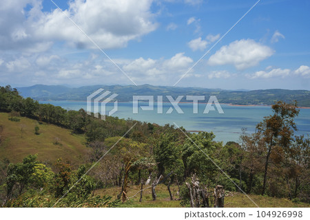 Scenic view of seascape amidst trees and mountain landscape under cloudy sky at Costa Rica 104926998