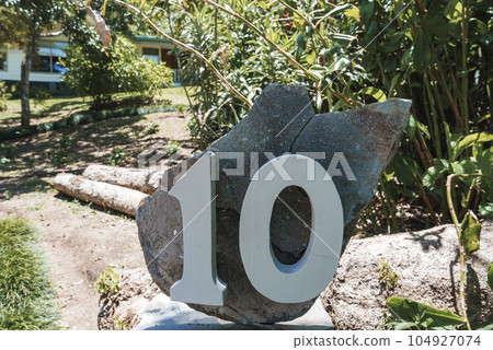 House number address 10 installed on a large rock at the yard of a residential structure at Costa Rica House number address 10 installed on a large rock at the yard of a residential structure at Costa Rica 104927074