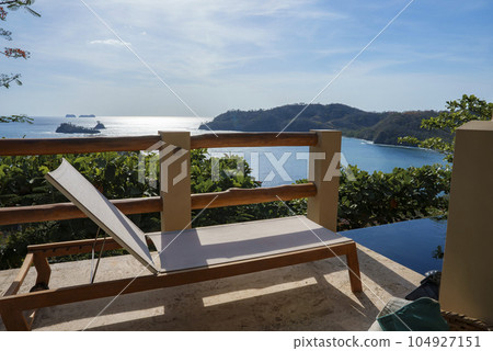 Luxury resort with deckchair by swimming pool in front of beautiful seascape during sunny day at Costa Rica Luxury resort with deckchair by swimming pool in front of beautiful seascape during sunny day at Costa Rica 104927151