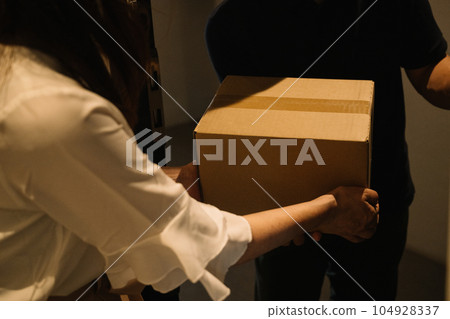 一位女士從快遞員那裡收到包裹 一位女士從快遞員那裡收到包裹 104928337