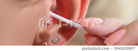 Woman cleaning her ear with cotton swab, people hygiene concept. 104928907