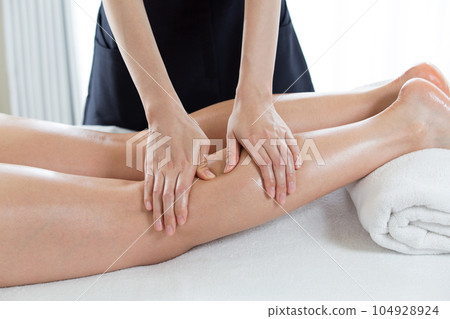 A woman is getting a calf massage. A woman is getting a calf massage. 104928924