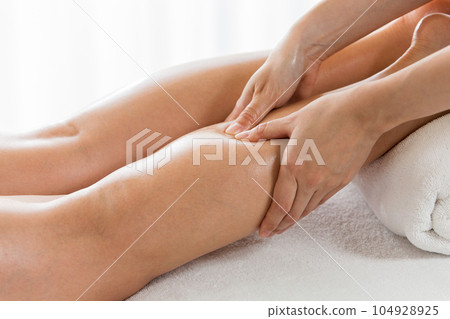 A woman is getting a calf massage. A woman is getting a calf massage. 104928925