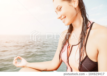 Woman sup yoga. Happy young sporty woman practising yoga pilates on paddle sup surfboard. Female stretching doing workout on sea water. Modern individual female outdoor summer sport activity. Woman sup yoga. Happy young sporty woman practising yoga pilates on paddle sup surfboard. Female stretching doing workout on sea water. Modern individual female outdoor summer sport activity. 104929417