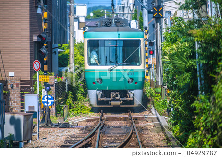 日本鎌倉市景 當地熱門線路江之電（後車）。私人住宅的屋簷和小鐵路道口的景象...... 104929787