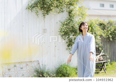 A woman in her thirties walking in the garden A woman in her thirties walking in the garden 104931962