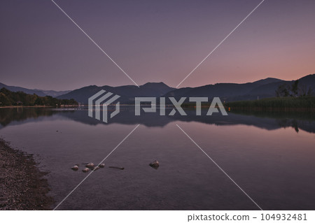 Lake with the reflection of mountains and lights on the water surface in Gmund am Tegernsee, Germany Lake with the reflection of mountains and lights on the water surface in Gmund am Tegernsee, Germany 104932481