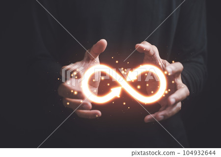 Businessman holds circular infinity symbol on dark background, representing circular economy and infinite possibilities. Strategy of sustainable investment, banking, and financial growth. Businessman holds circular infinity symbol on dark background, representing circular economy and infinite possibilities. Strategy of sustainable investment, banking, and financial growth. 104932644