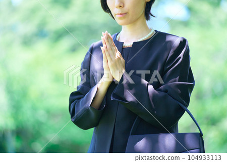 A woman who puts her hands together in a mourning dress 104933113