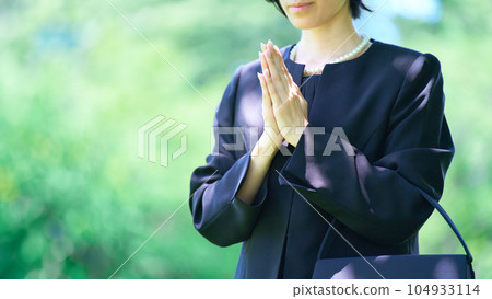 A woman who puts her hands together in a mourning dress 104933114