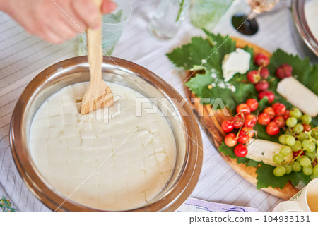 Master class and cheese tasting. Women make cheese. The enzyme and starter culture are added to the milk in a metal container. Milk folding process, home production, business, entrepreneur. Master class and cheese tasting. Women make cheese. The enzyme and starter culture are added to the milk in a metal container. Milk folding process, home production, business, entrepreneur. 104933131