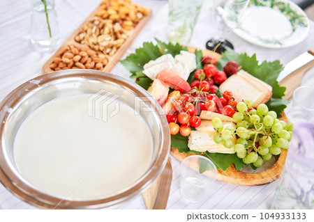 Making cheese from goat milk at home. Female and stir cheese sourdough with a spoon in a saucepan. Technology of cooking cheese. Cheese-making processes. Cooking concept 104933133