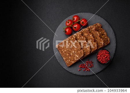 Delicious fresh crispy brown bread with seeds and grains cut into slices 104933964