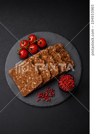 Delicious fresh crispy brown bread with seeds and grains cut into slices 104933965