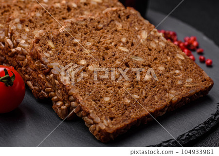 Delicious fresh crispy brown bread with seeds and grains cut into slices 104933981