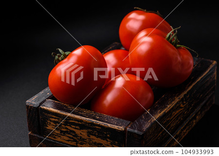 Delicious fresh juicy tomatoes on a dark concrete background 104933993