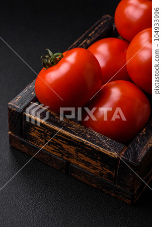 Delicious fresh juicy tomatoes on a dark concrete background 104933996