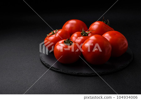 Delicious fresh juicy tomatoes on a dark concrete background 104934006