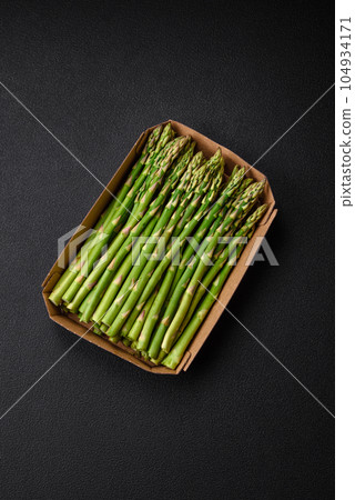 Delicious fresh sprigs of asparagus on a dark textured background 104934171