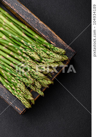 Delicious fresh sprigs of asparagus on a dark textured background 104934189
