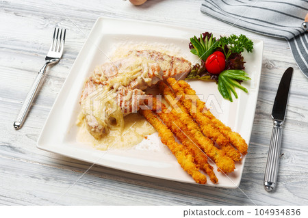 Chicken cooked in sauce and fried potato sticks served on plate 104934836
