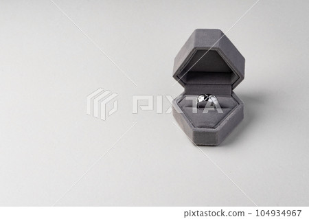 Golden ring in jewelry box on gray background Golden ring in jewelry box on gray background 104934967