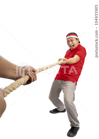 Indonesian men celebrate Indonesian independence day on 17 August with the tug of war contest Indonesian men celebrate Indonesian independence day on 17 August with the tug of war contest 104935905