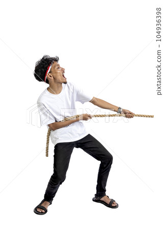 Indonesian men celebrate Indonesian independence day on 17 August with the tug of war contest 104936398