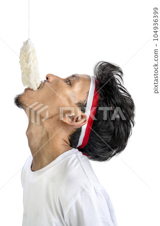 Indonesian men celebrate Indonesian independence day on 17 August with crackers eating competition Indonesian men celebrate Indonesian independence day on 17 August with crackers eating competition 104936399