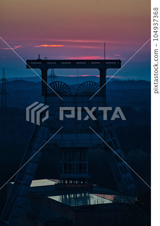 Vertical shot of a headframe tower after sunset at Halde Hoheward in Herten, Germany Vertical shot of a headframe tower after sunset at Halde Hoheward in Herten, Germany 104937368