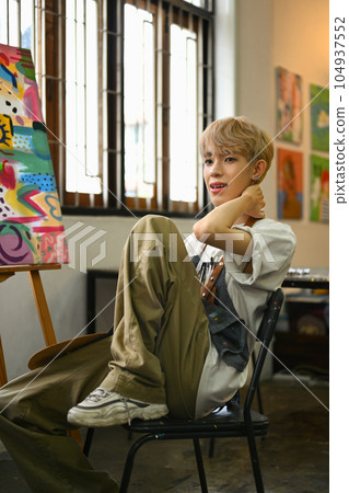Art, education, creativity and people concept. Asian student man painting on canvas with watercolors at art class Art, education, creativity and people concept. Asian student man painting on canvas with watercolors at art class 104937552