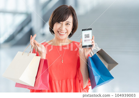 Middle-aged woman shopping with smartphone payment 104939003
