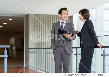 Middle-aged businessmen and women having a meeting in the office 104939036