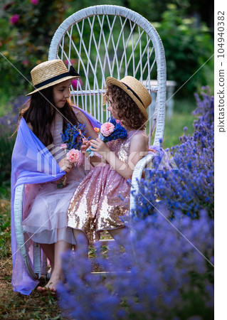 Romantic portrait o charming sisters in straw hats 104940382
