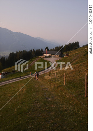 Beautiful scenic view of the Mountains with a cloudy sky, hikers in the sunrise in Austria 104940815