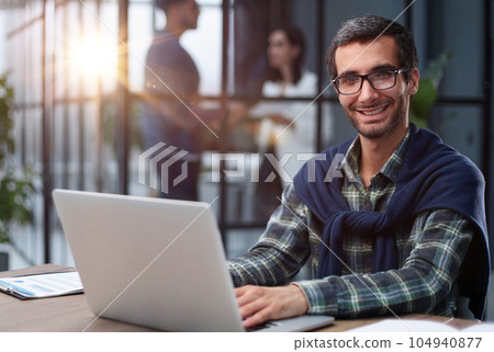 Pleasant happy man communicates in a social network, searches for information on the Internet. 104940877