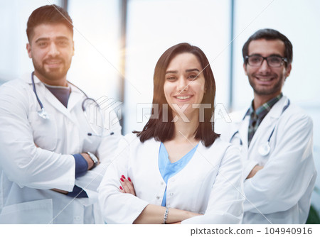 Three medical colleagues stand in the lobby of the hospital 104940916
