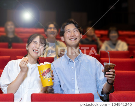 Couple watching a movie with a smile 104941240