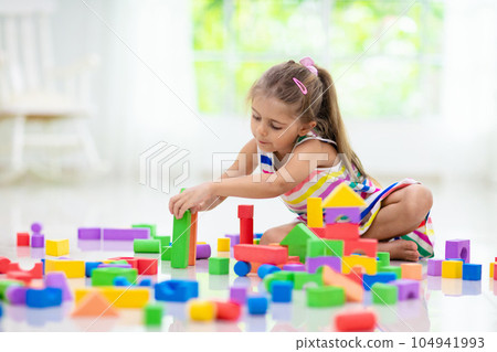 Child playing with toy blocks. Toys for kids. 104941993