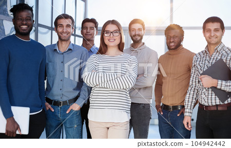 Confident in your team. Attractive young business people smiling while standing in a row with other people Confident in your team. Attractive young business people smiling while standing in a row with other people 104942442
