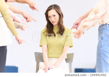 Young woman being pointed and criticized by many people 104942492