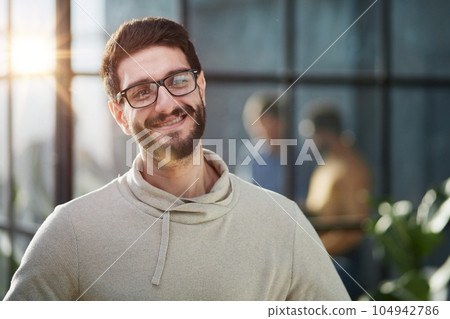Handsome young businessman in smart casual wear keeping arms crossed and smiling 104942786
