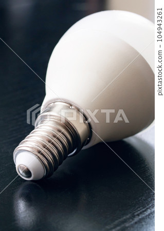 Light bulb base on black wooden table Light bulb base on black wooden table 104943261